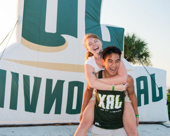 Students posing in front of Jacksonvillle University sign.